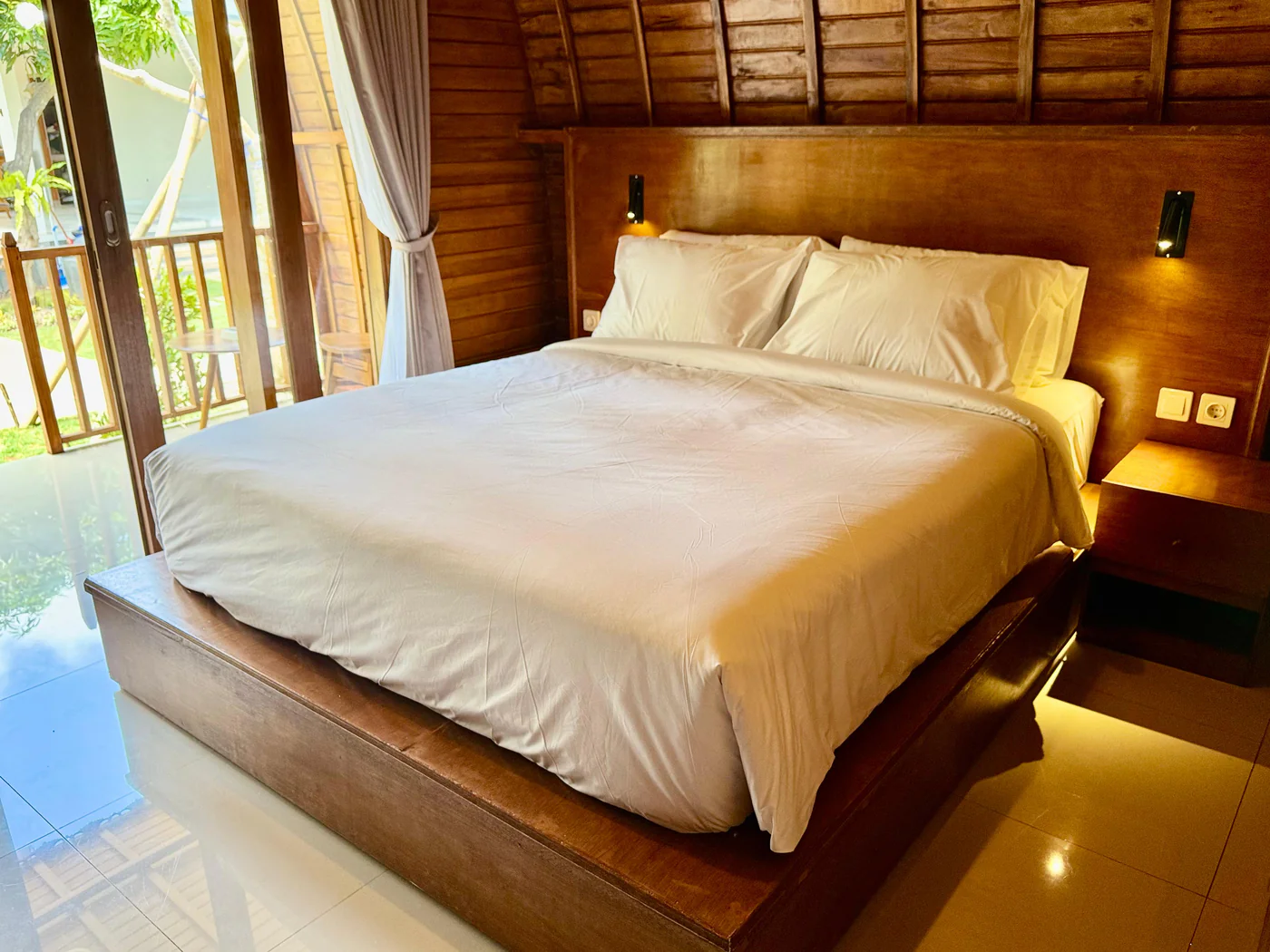 Private teak Lumbung interior with king bed and ambient lighting